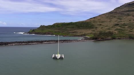 aerial view of a trimaran sailboat moored in a calm bay