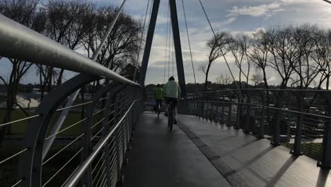 cyclists ride on a pedestrian bridge in auckland new zealand