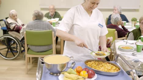 Cook plating pasta serving food in a nursing home
