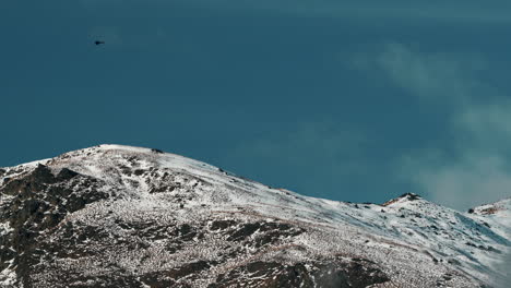 Helicóptero-Volando-Sobre-La-Montaña-Cubierta-De-Nieve-En-Queenstown,-Nueva-Zelanda