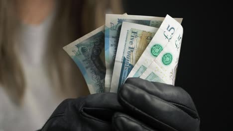 Hands-holding-up-English-cash-notes-to-camera-close-up-shot