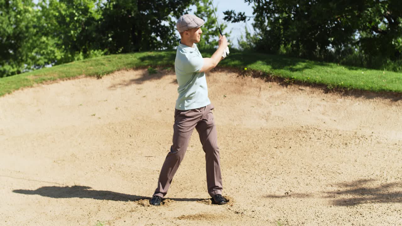 골퍼 가 모래 함정 에서 골프 를 치고 있다