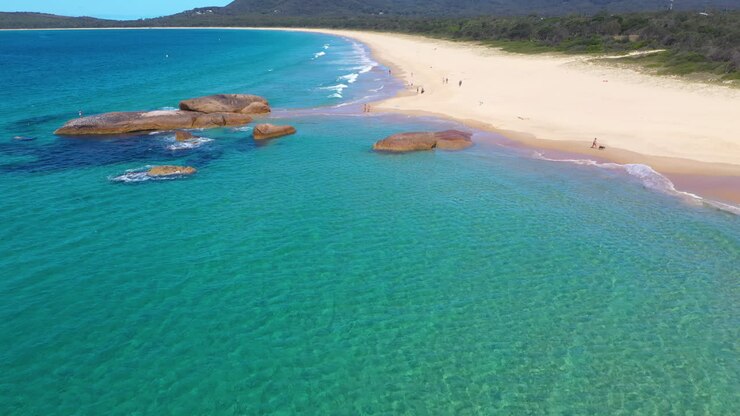 Ripresa aerea di bagnanti su una spiaggia tropicale australiana nel Nuovo Galles del Sud