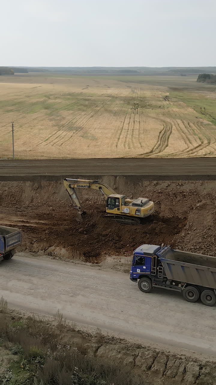 Excavator and Trucks on Construction Site