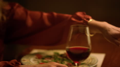 Old-couple-holding-hands-during-romantic-dinner