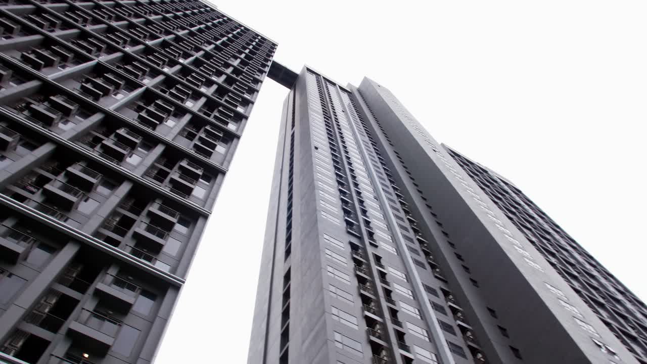 A low angle view in a public place looking up to see a very tall condominium
