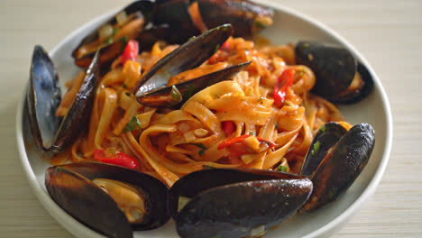 pasta de espagueti con mejillones o almejas y salsa de tomate - estilo de comida italiana