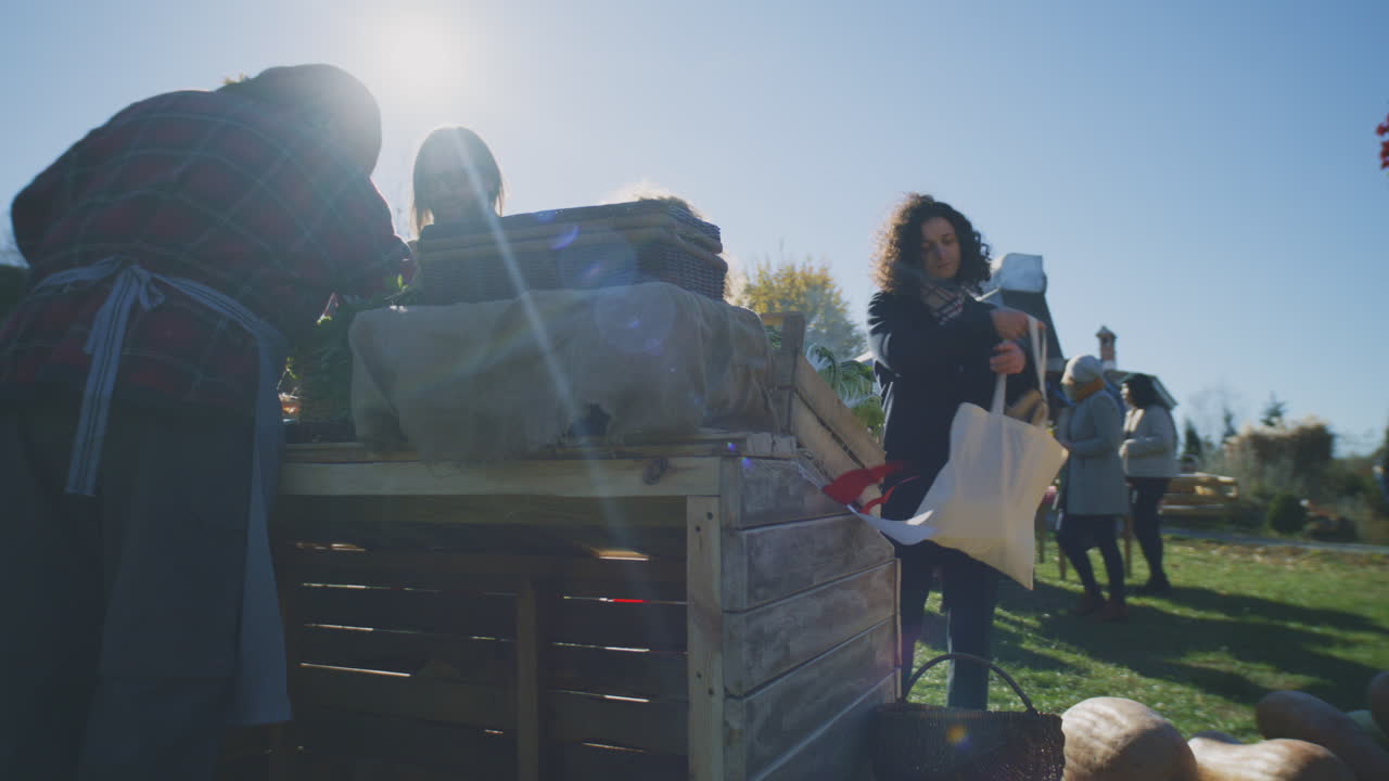 Couple put Products in Eco Shopper Couple Shopping at Local Farmers Market they Buy Fruits and Vegetables and put it in Eco Shopper Autumn Fair on Weekend Outdoors Vegetarian and Organic Food Agriculture Points of Sale system