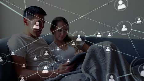 iconos de conexión de red contra pareja usando tableta digital en el hogar