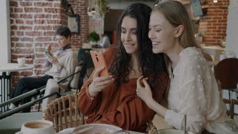 two women taking selfie in a cafe