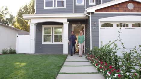 family coming out of front door of suburban home shot on r3d