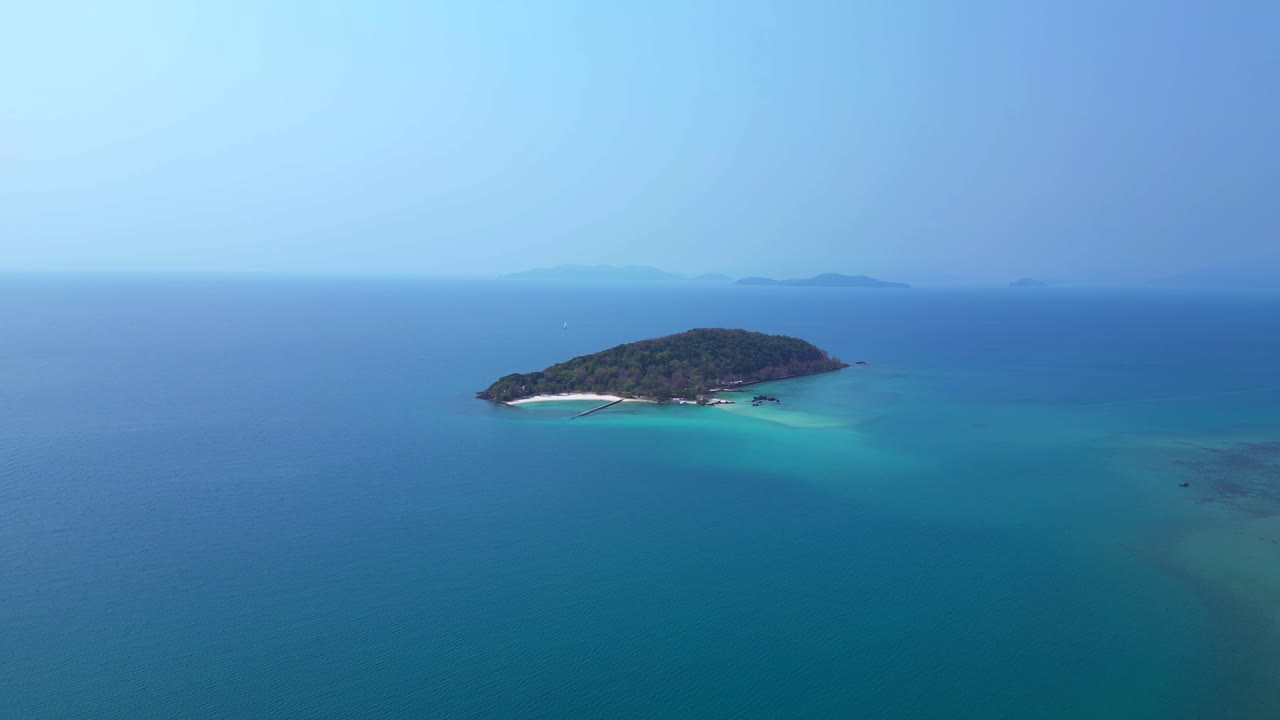 Palm trees bordering Ao Soun Yai Beach in Koh Mak, Thailand, with turquoise water. Unique aerial view flight descending drone
