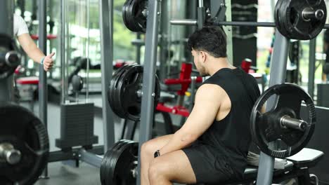 two men in a gym share a motivational moment during a workout, highlighting camaraderie and fitness dedication
