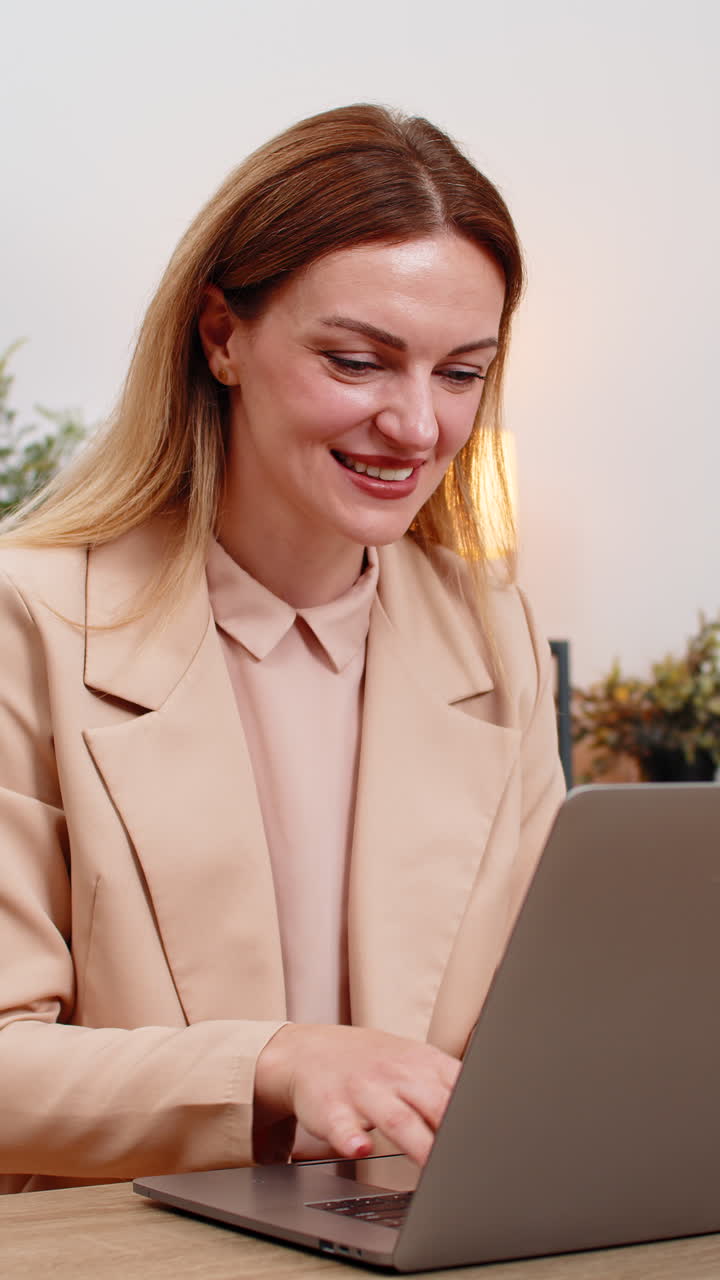 Businesswoman gets project approval message on laptop good news celebrates success victory gesture