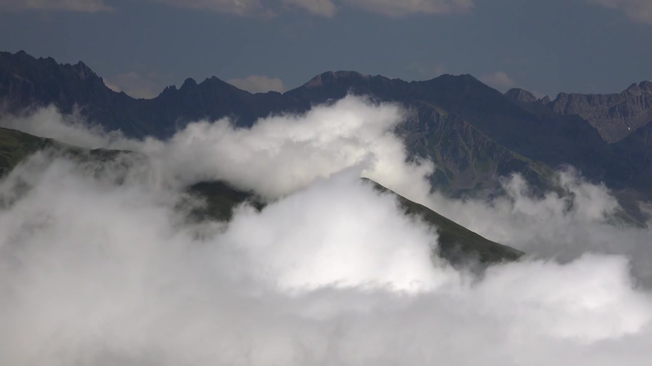 Thick Clouds Moving Over Green Mountain Peaks