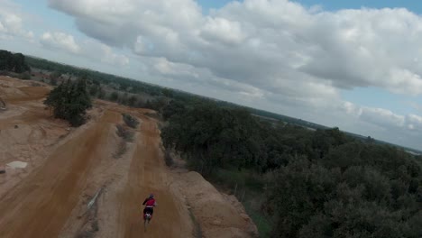 dirt motocross track with a rider riding over dirt ramps