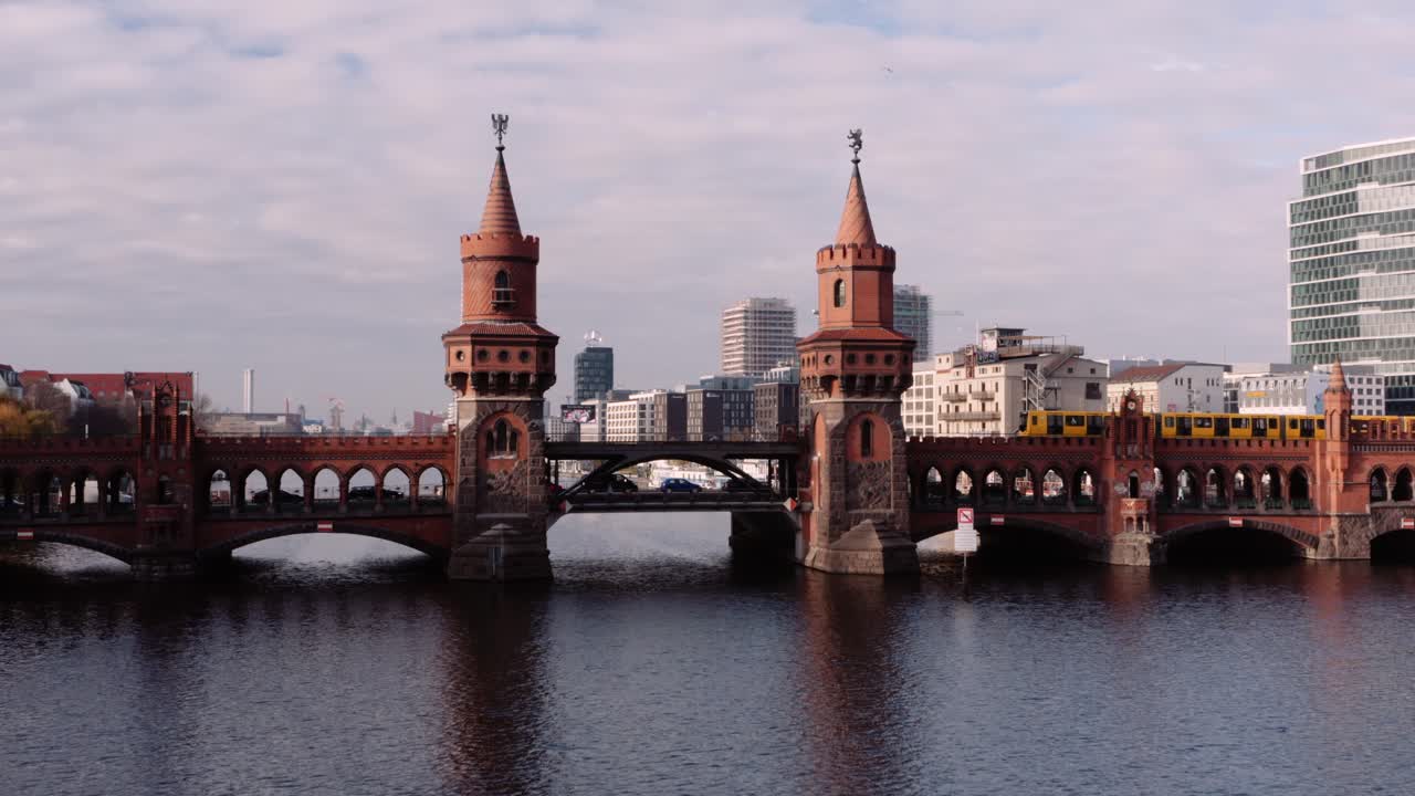 Ikonický most Oberbaumbrücke překlenující řeku Sprévu, přes který přejíždí vlak metra