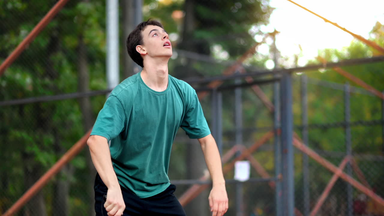 Young guy playing Pickleball, hitting the ball with a racket on an outdoor court. Slow motion