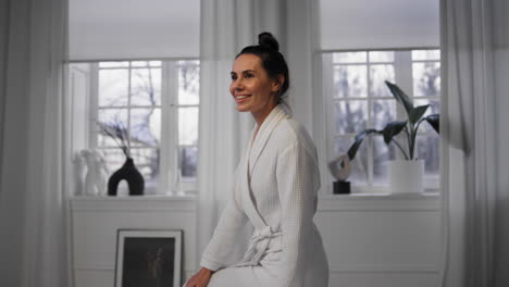 Happy-girl-sitting-bathtub-smiling-at-evening-home.-Lady-enjoying-spa-procedures