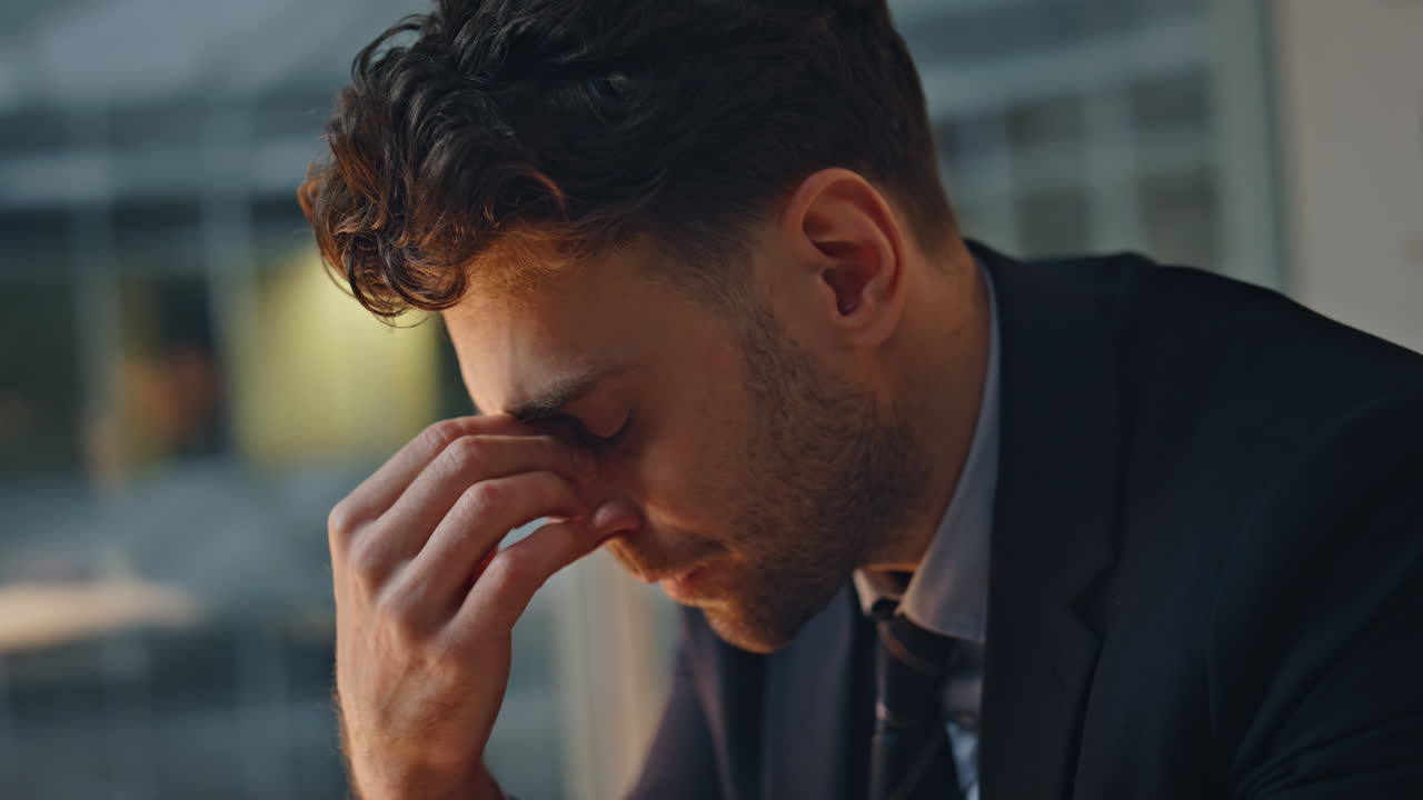 Overwhelmed businessman feeling stress working late evening in office closeup