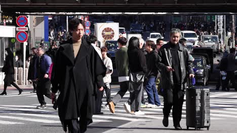 people crossing a busy city intersection