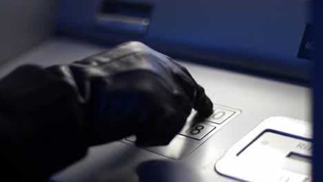a mysterious hand in black gloves interacts with an atm, typing in pin codes and potentially engaging in suspicious activity under dim light conditions