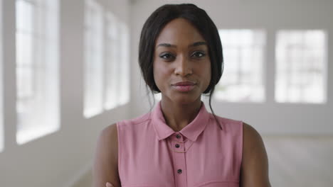 close-up-portrait-of-young-stylish-african-american-woman-smiling-confident-looking-boss-at-camera-arms-crossed-in-apartment-background