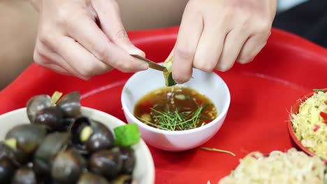 hands garnishing and seasoning a small bowl