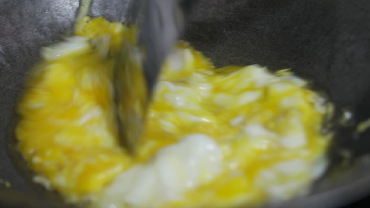 close up of frying and stirring eggs