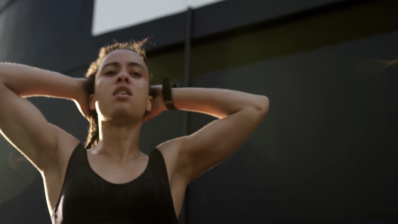 vista frontal de una joven mujer afroamericana sosteniendo su cabello en la ciudad 4k