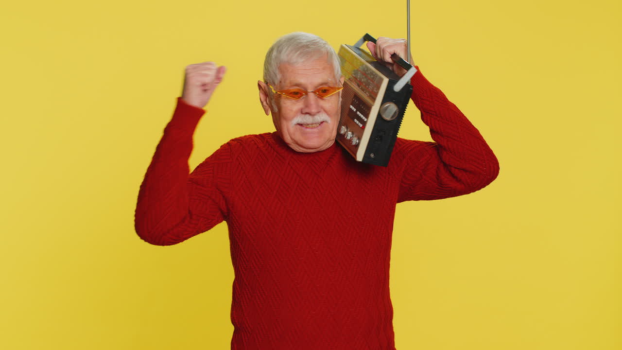 Happy old man listen music on retro tape record player disco dancing fan of vintage technologies