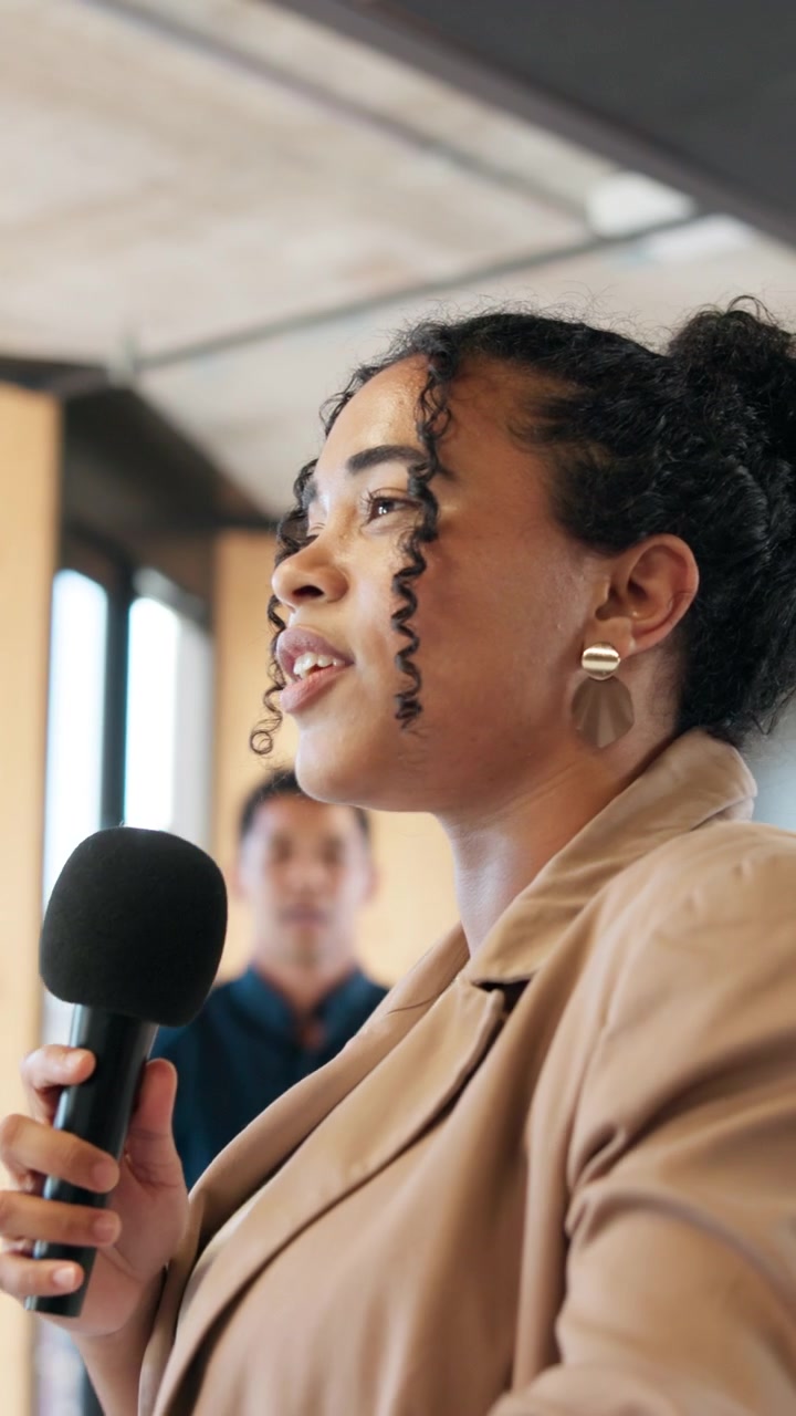 Young Woman Speaking into Microphone at Professional Business Meeting