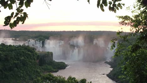 iguazu falls during sunset, horizon with tree branches and waterfall landscape