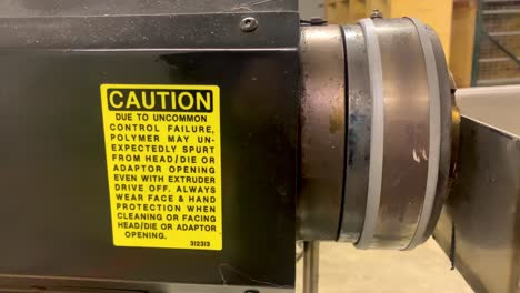 caution sign on extruder machine for extrusion manufacturing process