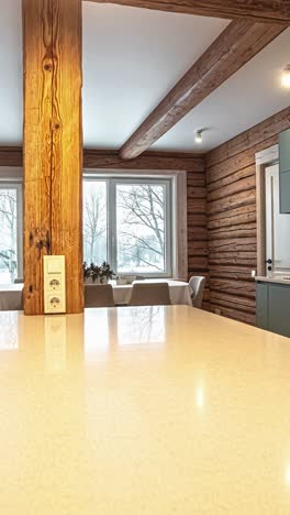 the interior of a cozy latvian home features a modern kitchen with sleek cabinets contrasting against traditional rustic log walls, with a snowy winter scene outside - vertical trucking