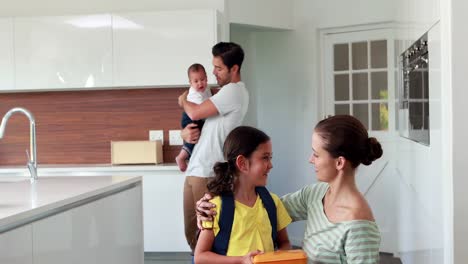 niño listo para la escuela en la cocina con la familia
