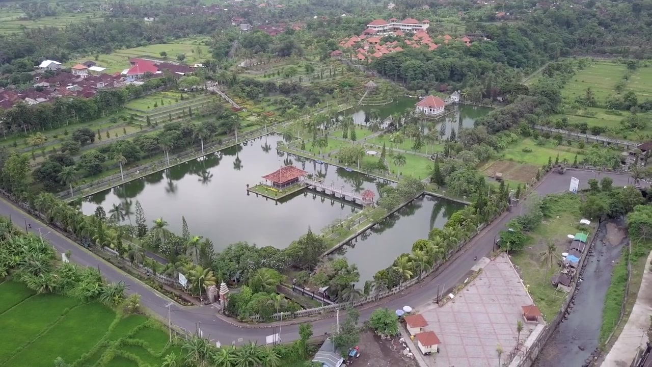 Pemandangan udara Istana Air Kerajaan Ujung yang terkenal, sudut tinggi, panning setengah lingkaran, dari kanan ke kiri. Hari berawan. Bali, Indonesia