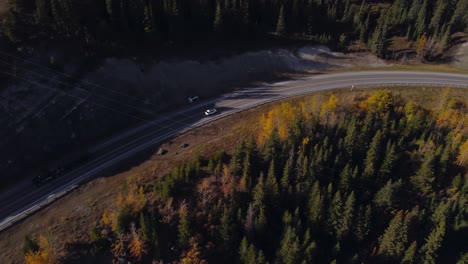 car on mountain road by lake followed