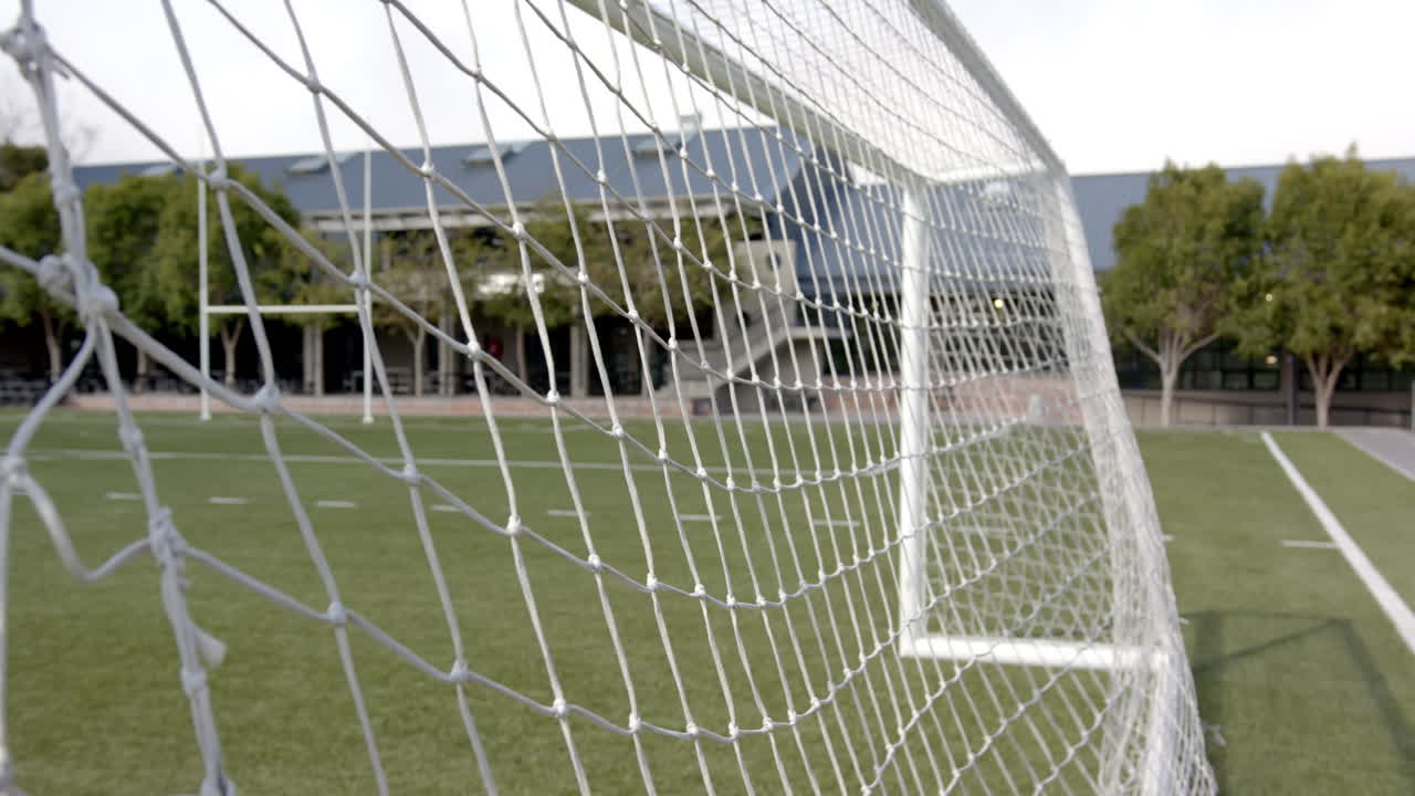 Soccer goal net on field, focusing on sports equipment and outdoor activity