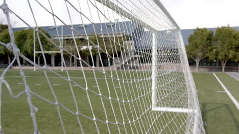 soccer goal net on field, focusing on sports equipment and outdoor activity