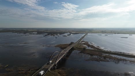 road-bridge-water-river-overflow-sunny-day-aerial-circulating-view-right