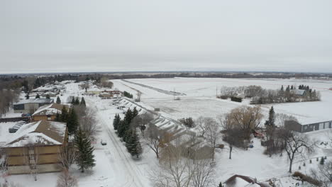 aerial view flying over a small, snow-covered canadian community in the prairies