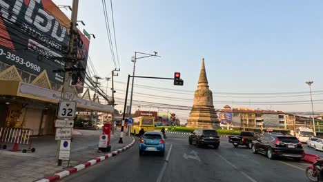 vehicles pass by a historic pagoda in ayutthaya