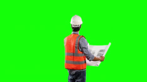 side view of site worker looking at a site map with green screen