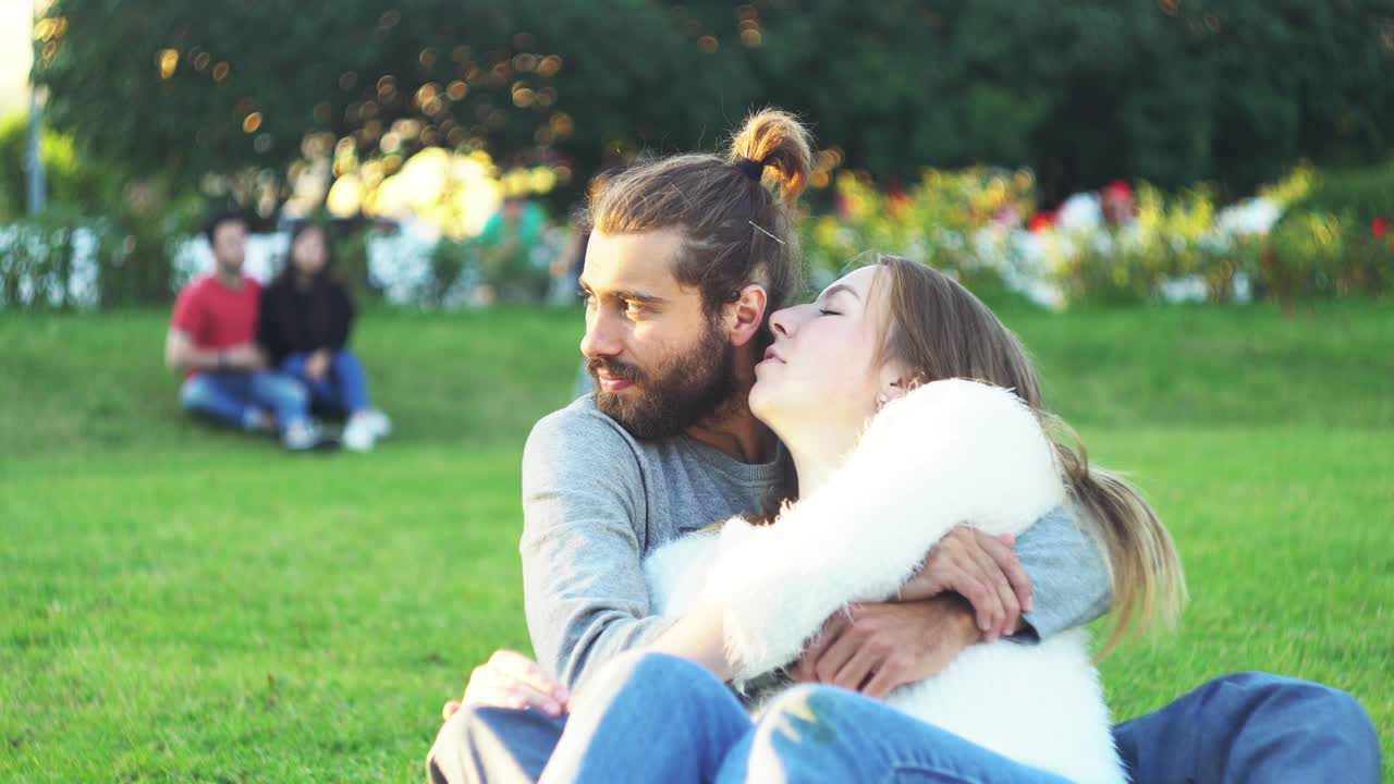 una pareja abrazándose en un parque.