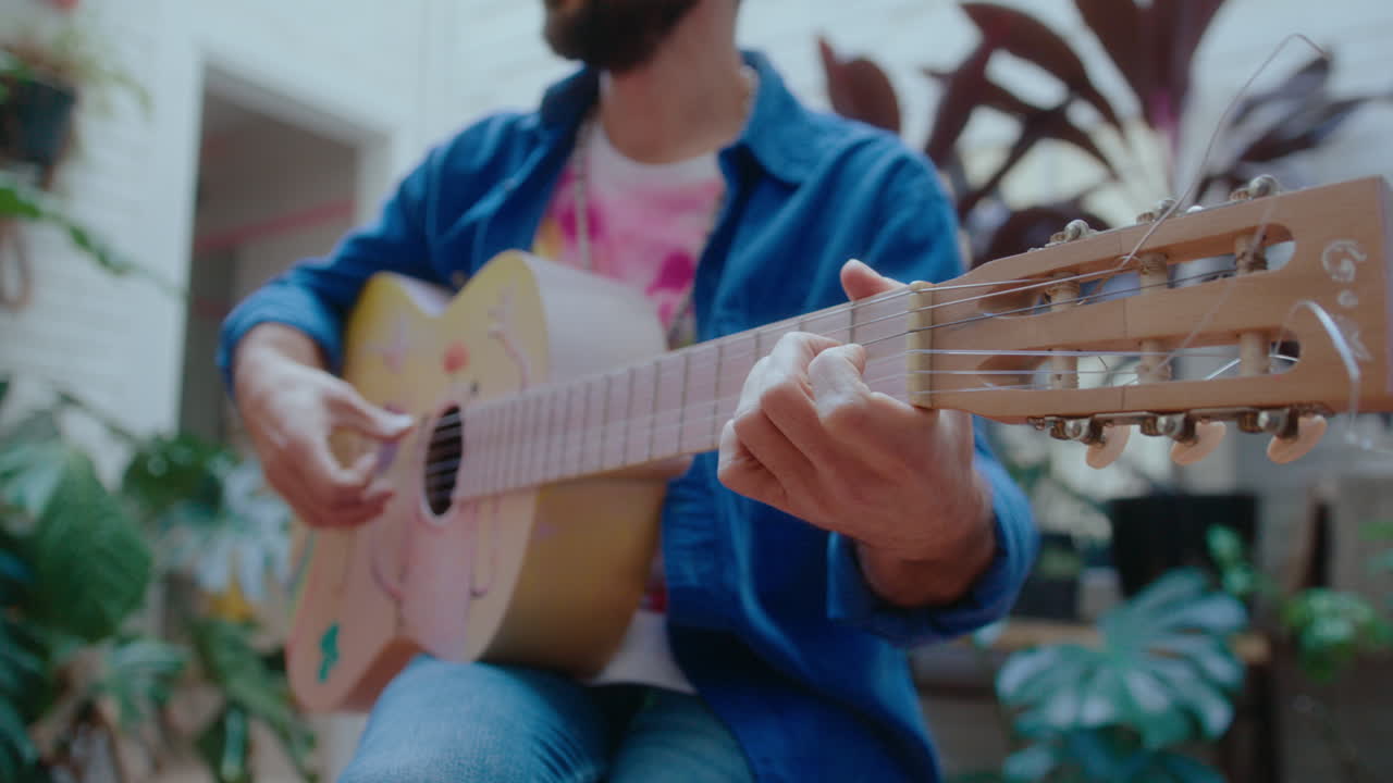 Musician Playing the Guitar Outdoors at Balcony Garden