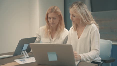 Pretty-Young-Blonde-Women-Having-A-Business-Video-Call-And-Showing-Documents-With-Charts-And-Graphs