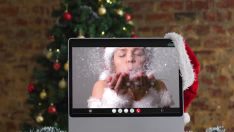 mujer caucásica en disfraz de santa en llamada de video en la computadora, con decoraciones de navidad y árbol