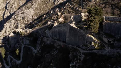 aerial - ancient city walls of kotor, montenegro, a world heritage site, spinning shot