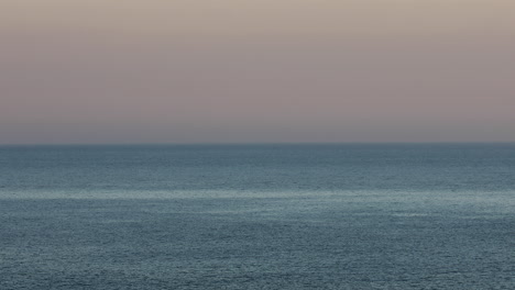 Escena-Tranquila-Que-Captura-El-Amanecer-Y-Fusiona-Perfectamente-El-Mar-Con-El-Cielo-En-El-Horizonte-Lejano